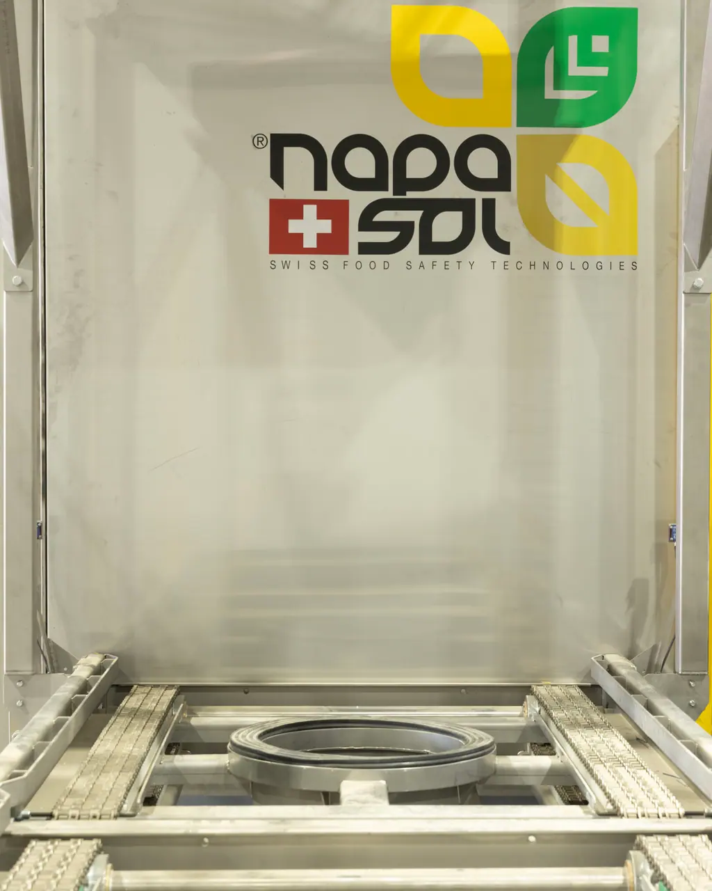The open stainless steel door of the Napasol steam sterilisation vessel, with the product conveyor and its sealing gasket in the foreground.